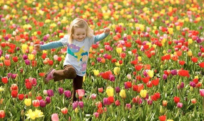 criança brincando com as flores